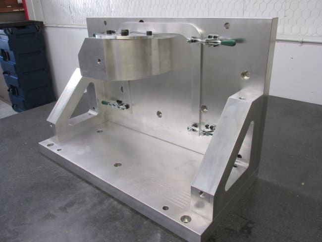Aluminum assembly fixture with clamps on a machined base plate