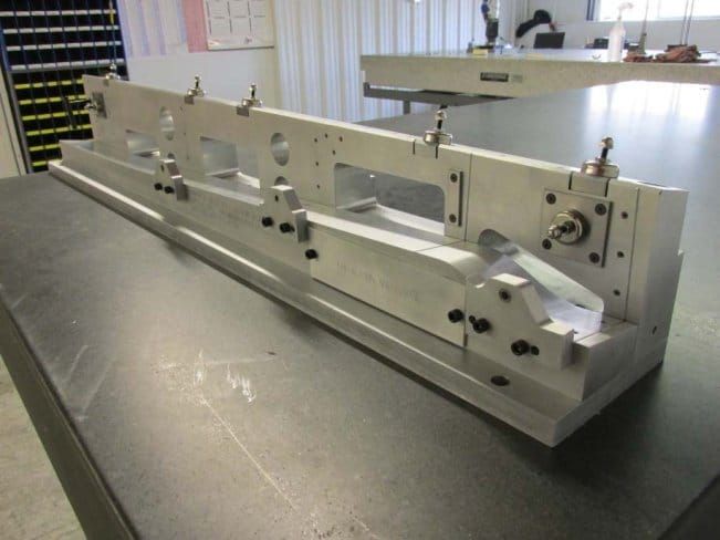 Aluminum laser holding fixture on a surface table